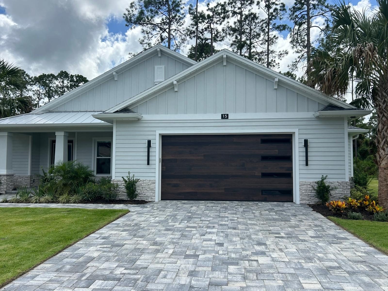 Dark walnut plank garage door installed on a Florida home