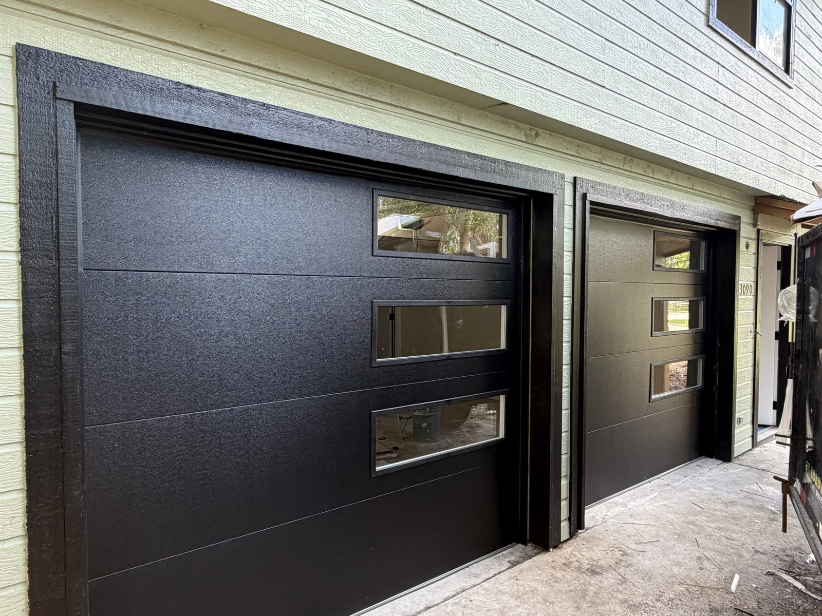 Modern black garage doors with glass window inserts