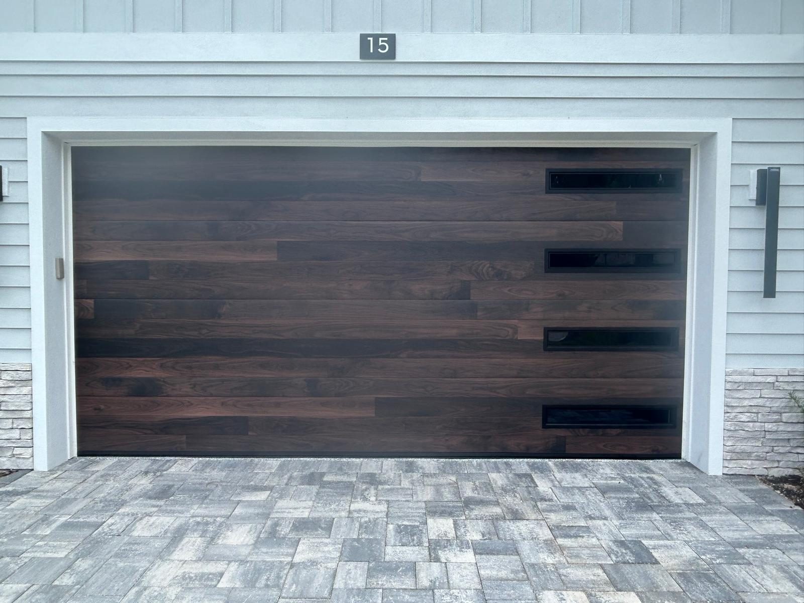 Dark walnut plank garage door with black window inserts